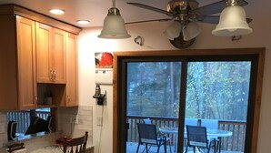 A kitchen with granite countertops, wooden cabinets, and a dining area with a table and chairs. - Expansive Lakehouse with Jacuzzi (Argyle)