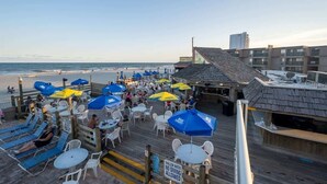 A beachside restaurant with outdoor seating, umbrellas, and a view of the ocean. - Oceanfront Corner, Low Floor, Ocean Annies, Pools! (Myrtle Beach)
