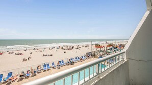 A beach view from a balcony with sun loungers and a pool. - Oceanfront Corner, Low Floor, Ocean Annies, Pools! (Myrtle Beach)