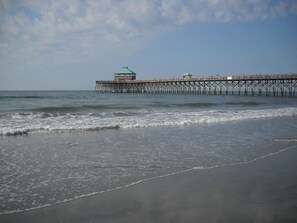 A pier extending into the water with a small building at the end. - Beachfront Condo 500 Steps to the Ocean (Folly Beach)