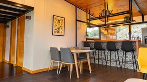Una cucina moderna con angolo bar, soffitto in legno e tavolo da pranzo con sedie.