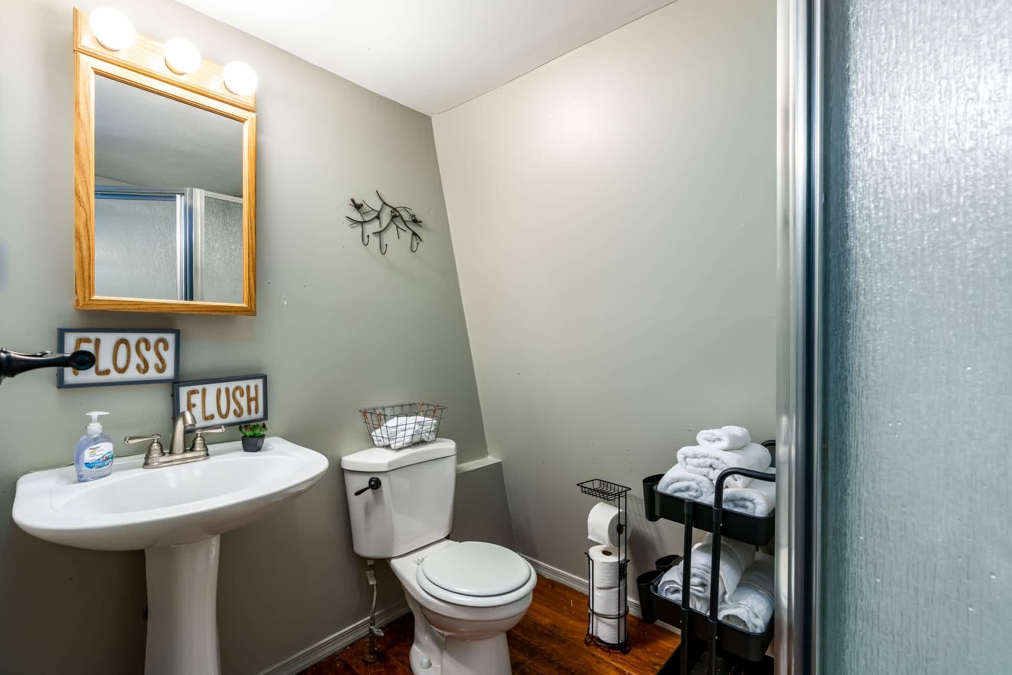 Une salle de bain équipée d’un lavabo, de toilettes et d’un porte-serviettes.