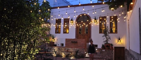 An outdoor patio area with string lights, tables, and chairs.