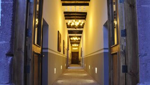 A long, narrow hallway with wooden doors and a series of chandeliers. - Clandestino Hotel Recreo - Adults Only (San Miguel de Allende)