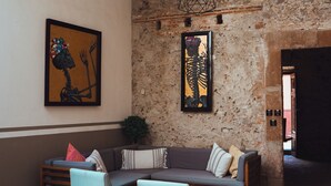 Ein Essbereich mit einer Steinwand, einer hölzernen Bank und einem Tisch mit Stühlen.