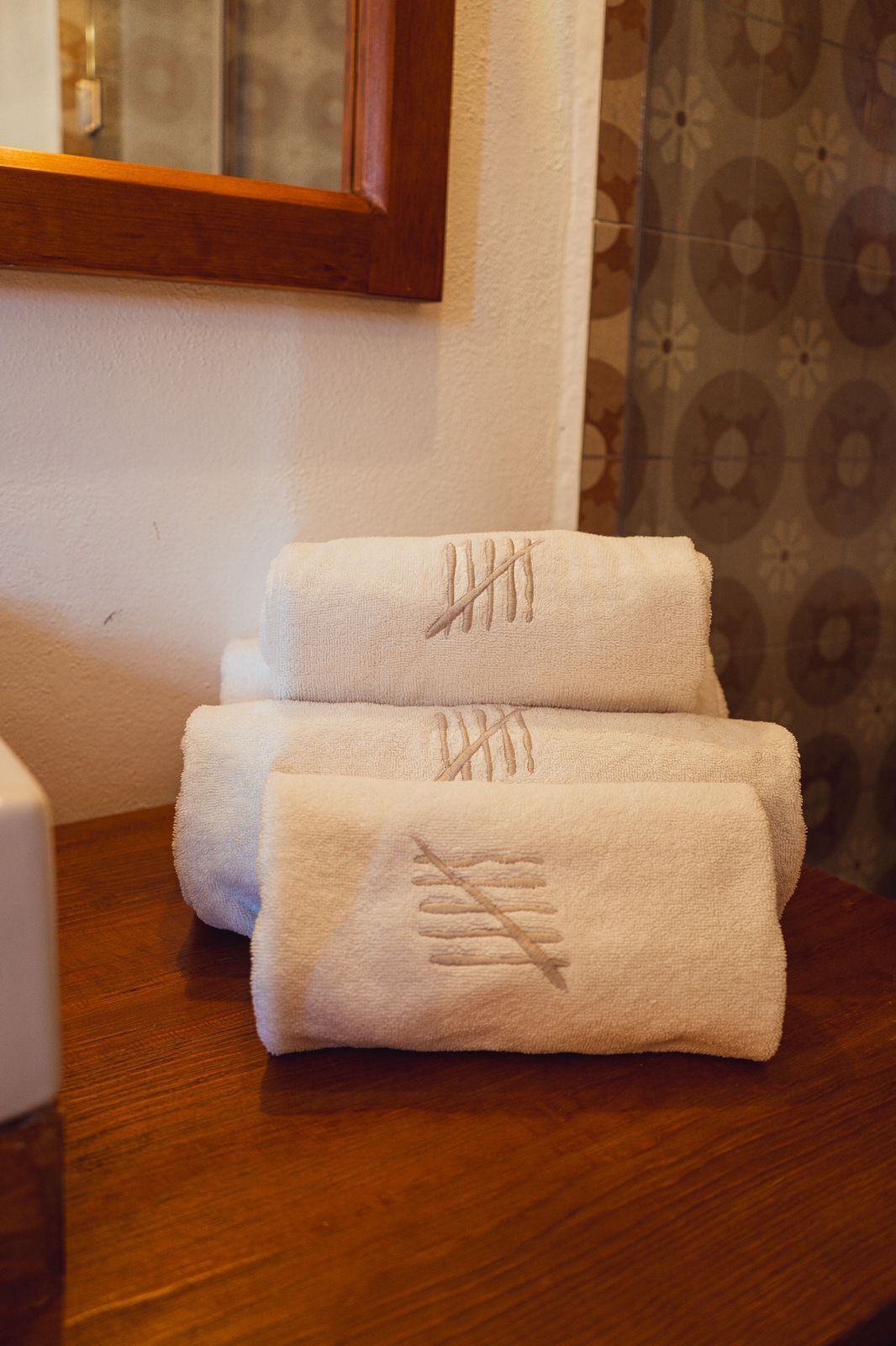 Two neatly folded towels with a diagonal cross pattern on a wooden table.