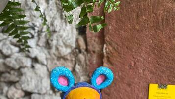 A decorative skull with a bear face, blue ears, and a pink nose, mounted on a pole.