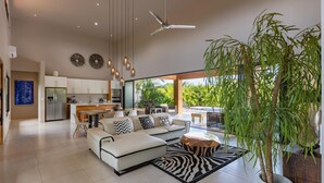 Uma sala de estar moderna com sofá, mesa de centro e uma grande planta em vaso.