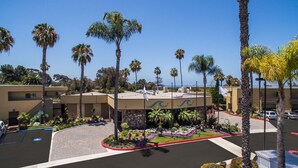 A hotel with a parking lot, palm trees, and a view of the ocean. - 1 Bedroom/1 Bathroom Sleep 4 SC (San Clemente)