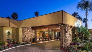 A hotel entrance with a stone facade, a clear sky, and a well-maintained garden. - 1 Bedroom/1 Bathroom Sleep 4 SC (San Clemente)