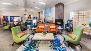 A spacious lobby with green armchairs, a central coffee table, and a large TV screen. - 1 Bedroom/1 Bathroom Sleep 4 SC (San Clemente)