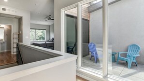A modern interior with a balcony, a dining area, and a kitchen. - Private Elevator in Hot South Slope (Asheville)