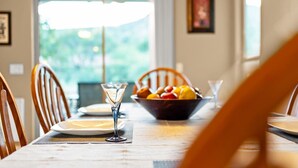 A dining table with a bowl of fruit, a martini glass, and a white plate. - 10 Min-Buddha Beach- Oak Creek | Pet & RV Friendly (Sedona)