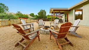 An outdoor seating area with Adirondack chairs, a fire pit, and a covered patio. - 10 Min-Buddha Beach- Oak Creek | Pet & RV Friendly (Sedona)