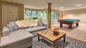 A living room with a gray sectional sofa, a wooden coffee table, and a pool table. - Spacious Elk Mountain Sanctuary w/ Deck & Views! (Asheville)