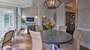 A dining area with wicker chairs, a round table, and a vase of flowers. - Spacious Elk Mountain Sanctuary w/ Deck & Views! (Asheville)