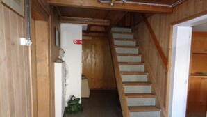 A wooden staircase leading to a lower level, with a white door at the bottom.