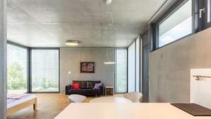 A modern interior with a kitchen area, dining space, and a sofa set.
