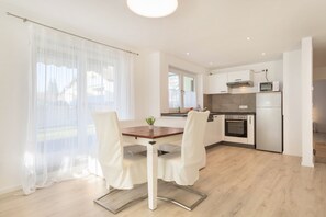 A modern kitchen with white cabinets, a built-in oven, and a microwave.