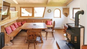 A cozy wooden interior with a large table, benches, and a wood-burning stove. - großes Ferienhaus St. Sigmund (Sankt Sigmund)