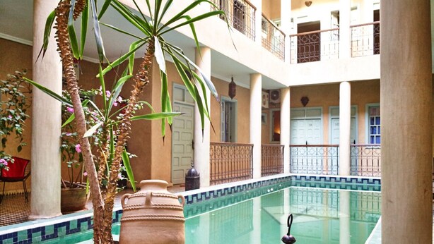 A courtyard with a pool, columns, and potted plants. - Bienvenue au Riad Taroudant ! (Taroudant)