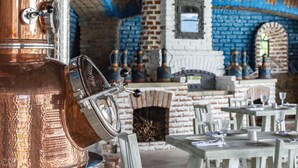 A copper distillation apparatus, brick walls, and a brick fireplace in a rustic setting. - Villa Mosavali (Mtskheta)