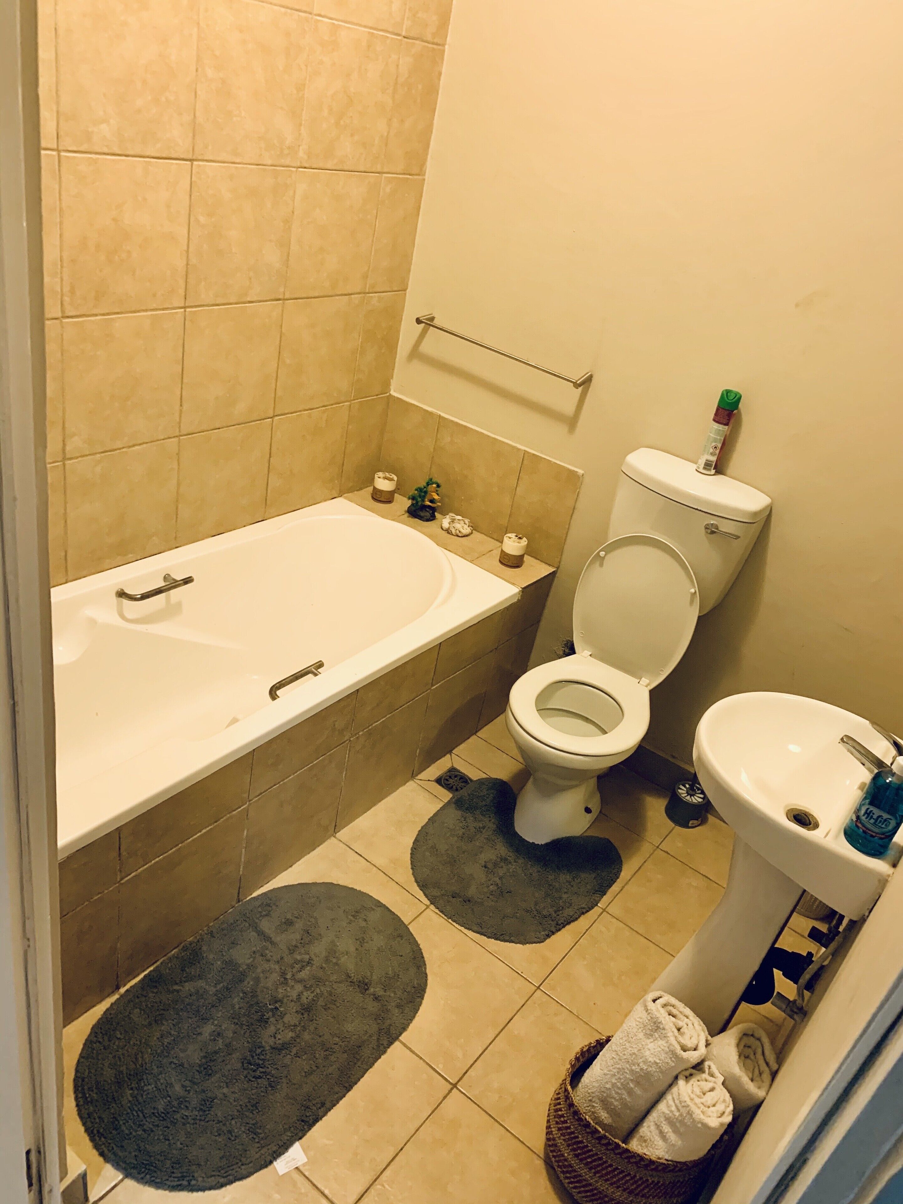A bathroom with a bathtub, toilet, sink, and a towel rack.