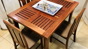 Ett matbord i trä med fyra stolar, ett bricka med olika tillbehör och en skål märkt med texten ”SOppa”.