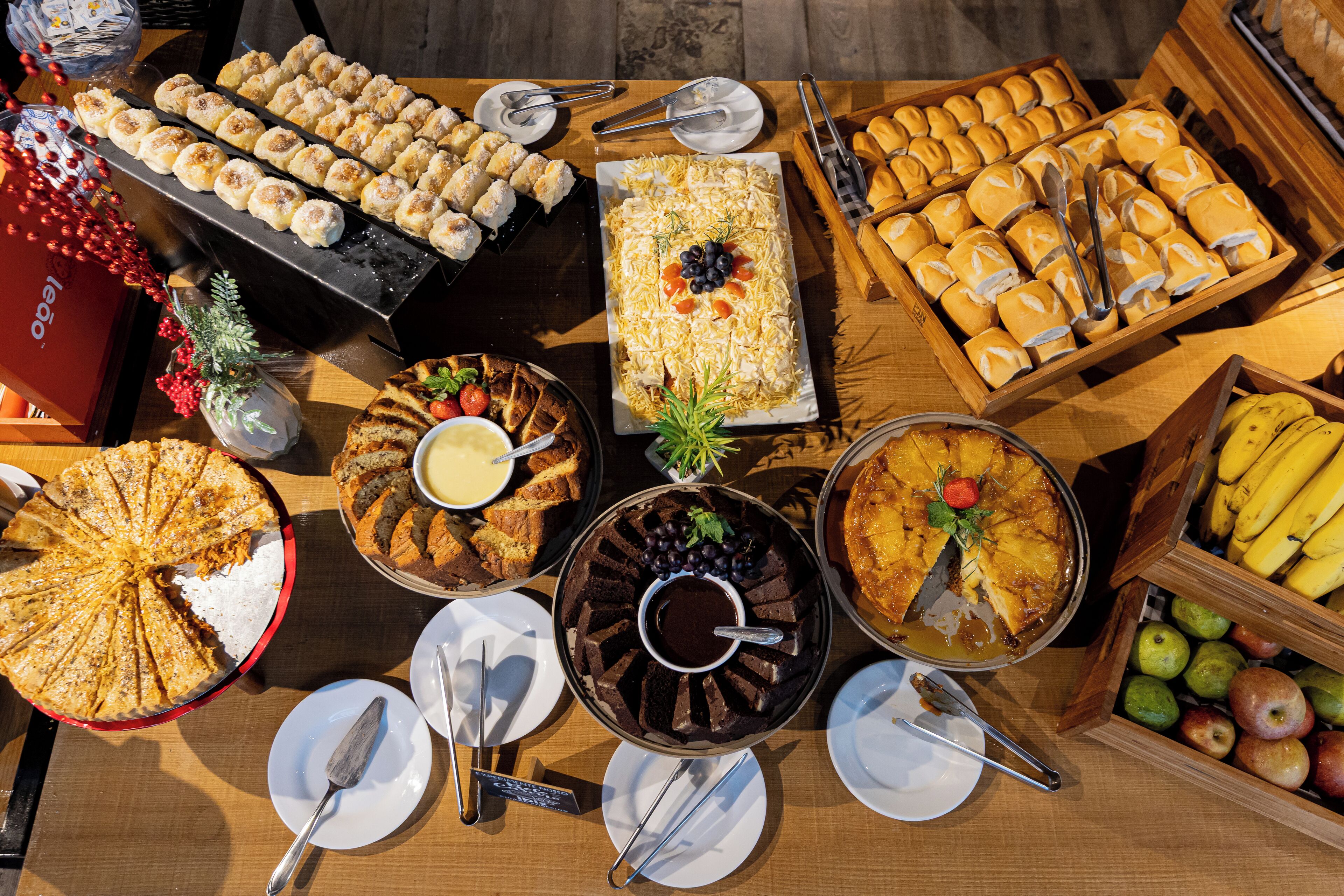 A buffet with various food items including a cake, pastries, and fruits.