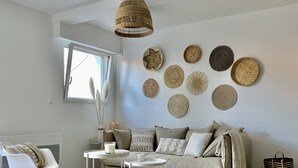 Un salon moderne avec un canapé, une table basse et des paniers décoratifs en osier accrochés au mur.