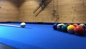 A pool table with a blue felt surface, surrounded by various colored billiard balls, in a room with wooden walls and a wooden ladder leaning against the wall. - Breathtaking Panoramic Alpine Views (Abondance)