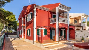 Un bâtiment rouge doté d’un balcon, d’une porte et d’une fenêtre.