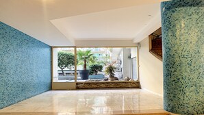 A spacious interior with a polished marble floor, a large potted plant, and a view of the outside through a glass door. - N&J  - BEETHOVEN - Central - Residental area (Niza)
