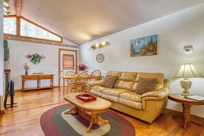 Una sala de estar con un sofá de cuero, una mesa de centro de madera y un comedor con una mesa y sillas de madera.