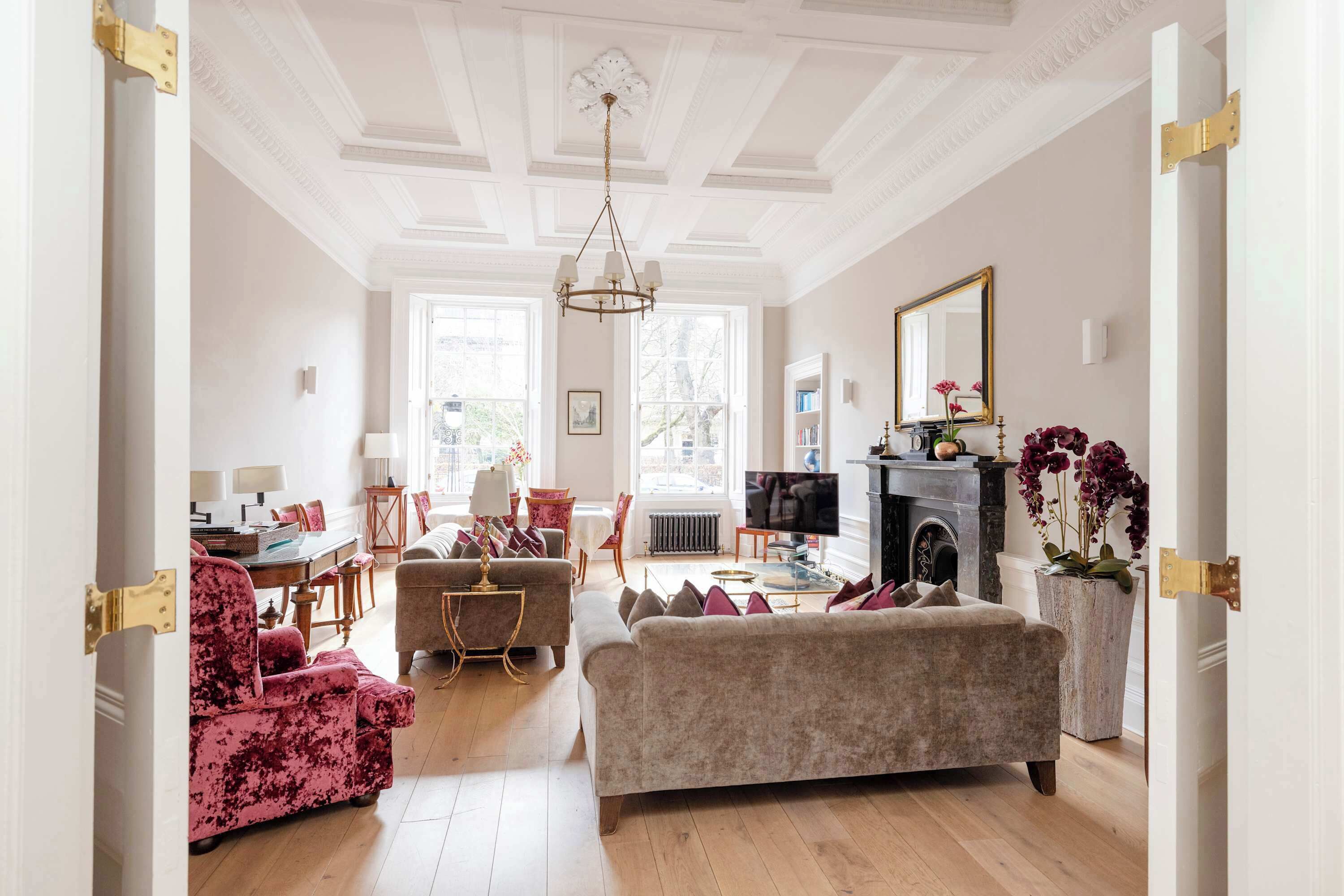 A spacious living room with a fireplace, a television, and a dining area with a table and chairs.