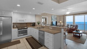 A modern kitchen with white cabinetry, stainless steel appliances, and a large island. - 1704-17th Flr-BEACH CHAIRS & UMBRELLA INCL-HOT TUB-Outdoor POOL-BEACH VIEWS (Panama City Beach)