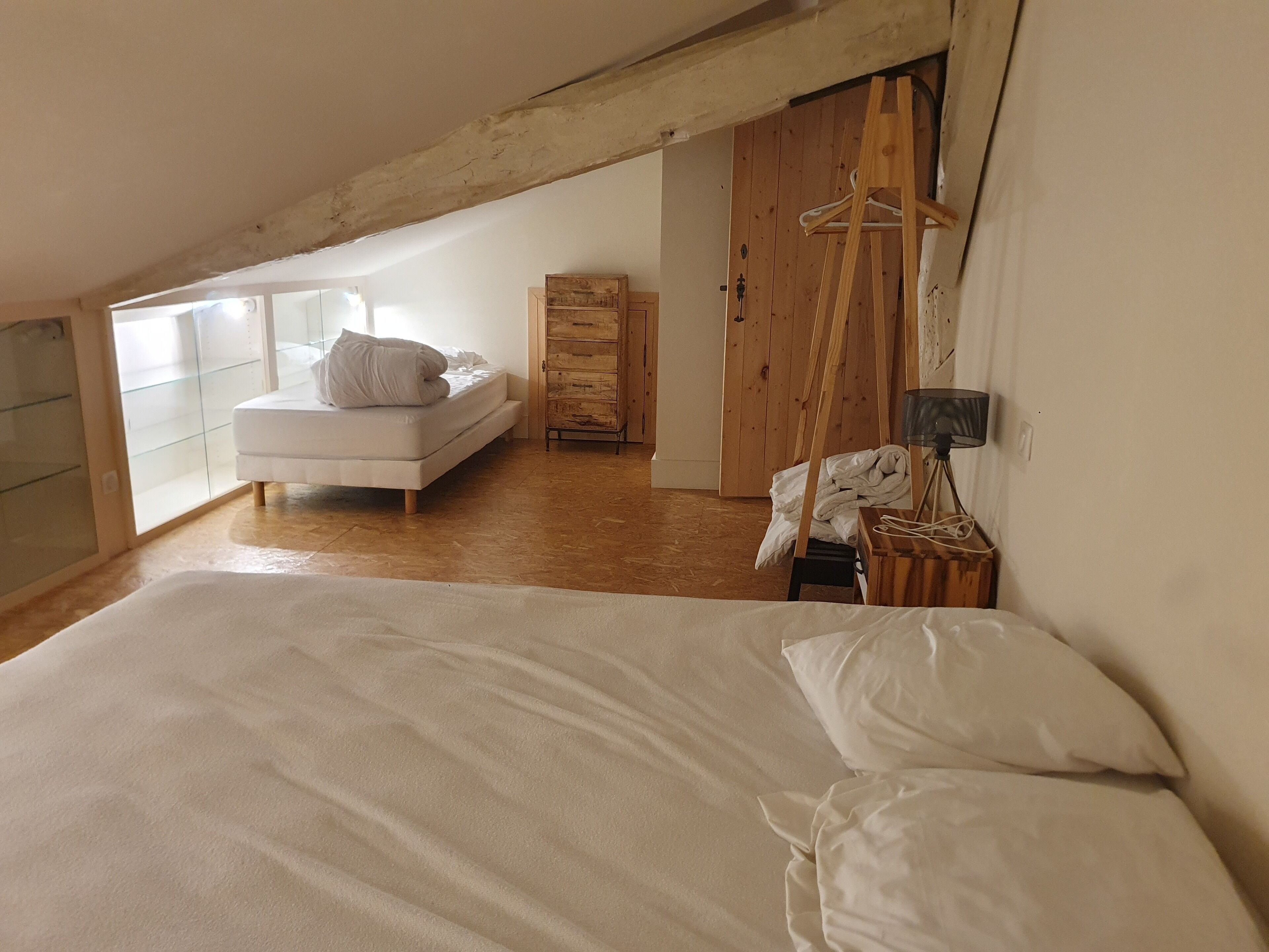 Ein Schlafzimmer mit einem großen Bett, einem Holzschrank und einer Kleiderstange.