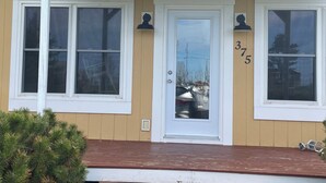 A two-story house with a front porch, a white door, and two windows on the upper floor. - Beautiful Family Retreat, Cavendish area. (Nous sommes bilingues) (Kensington)