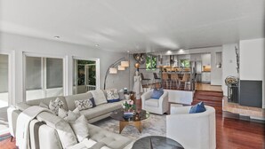 A spacious living area with a sofa, armchairs, a coffee table, and a fireplace.