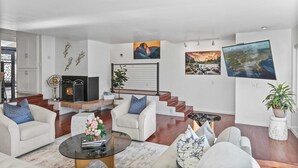 A modern living room with a fireplace, comfortable seating, and artwork on the walls.