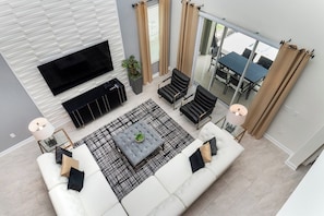 Luxury Retreat: Our townhouse living area is a masterpiece of sophistication, offering guests an unparalleled experience of indulgence and comfort - Lush 5BR Home w/ Pool, Game & Themed Rooms (Kissimmee)