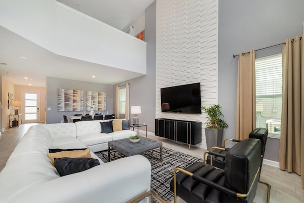 Luxury Retreat: Our townhouse living area is a masterpiece of sophistication, offering guests an unparalleled experience of indulgence and comfort - Lush 5BR Home w/ Pool, Game & Themed Rooms (Kissimmee)