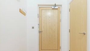 A wooden door with a metal handle and a small shelf above it. - Chic 1 BDR APT w Balcony in Shepherd's Bush (London)