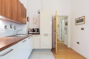 A modern kitchen with wooden cabinets, a built-in sink, and a refrigerator.