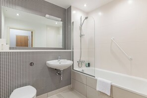 A bathroom with a white sink, a mirror, a shower, and a bathtub.