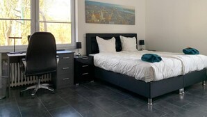 A bedroom with a bed, a desk, and a chair. - Ferienwohnung Am Geroweiher (Mönchengladbach)