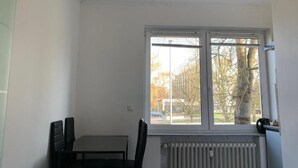 A room with a window, a radiator, and a table with chairs. - Ferienwohnung Am Geroweiher (Mönchengladbach)