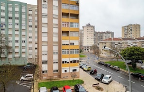 Ein mehrgeschossiges Wohngebäude mit Parkplatz davor.