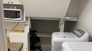 A compact laundry room with a microwave, a washing machine, and a dryer. - Be At Home Away From Home III (Welland)