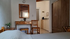 A bedroom with a bed, a wooden desk, a chair, a mirror, and a wardrobe. - Pension Zoi (Rhodes)
